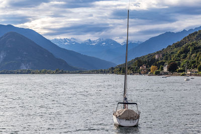 Sailboat in lake against mountains