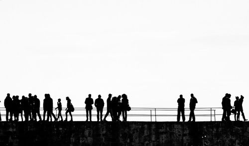 Silhouette people against clear sky