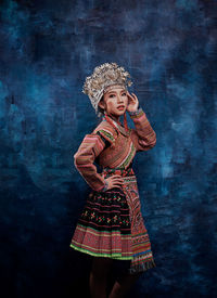 Portrait of smiling girl standing against wall