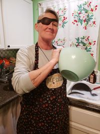 Mid adult man holding balloons at home