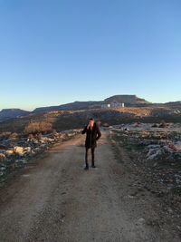 Man walking on mountain against clear sky