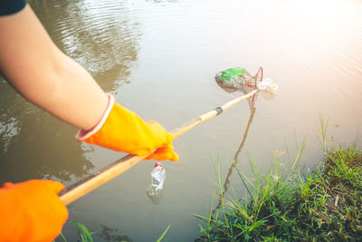 Low section of woman cleaning lake