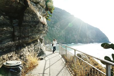 Woman standing by railing on mountain