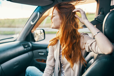 Midsection of woman sitting in car