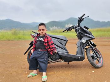 Pose of a child on a mountain with a motorbike