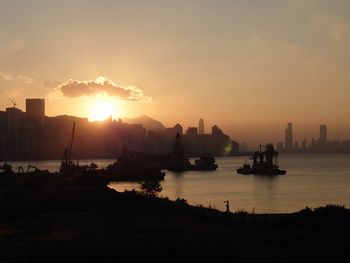 Silhouette boats in bay against sky during sunset