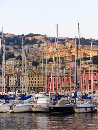 Boats moored in sea by town