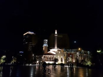 People on illuminated buildings at night