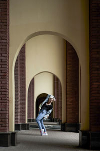 Side view of woman standing against building