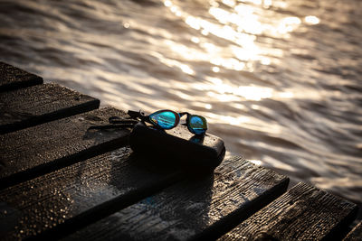 Close-up of sunglasses on beach against sky during sunset