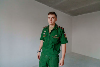 Portrait of soldier standing against wall