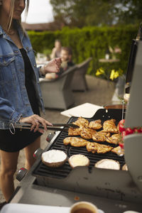 Woman preparing food on barbecue