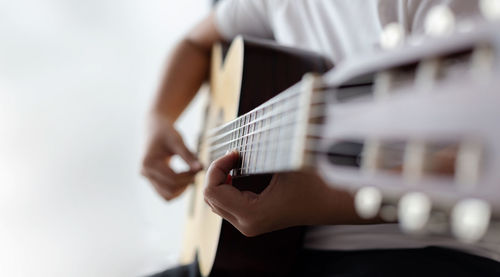 Midsection of person playing guitar