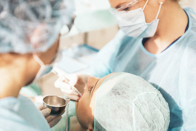 Dentists examining woman at clinic