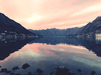 Scenic view of lake by mountains against sky during sunset