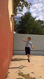 Full length of boy playing on basketball court