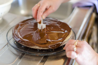 Cropped hand making cake at home