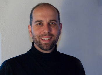 Portrait of young man standing against wall