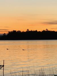 Scenic view of lake against orange sky