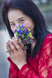 Close-up portrait of woman holding flowers