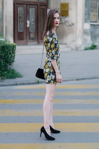 Portrait of young woman standing on street