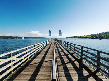 Pier over sea against blue sky