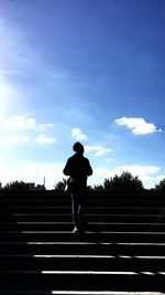 Rear view of silhouette man walking on staircase