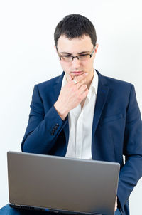Mid adult man using smart phone against white background