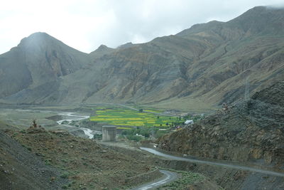 Road leading towards mountains against sky