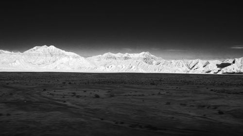 Scenic view of snowcapped mountains by sea against sky