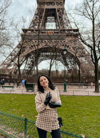 Lady near eiffel tower in paris, france was made in winter. no snow, only some rain on the street.