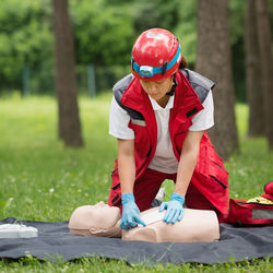 Healthcare worker practicing on cpr dummy at park