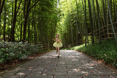 Rear view of woman walking in forest