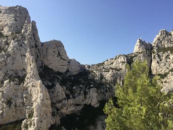 Low angle view of rocky mountains against clear sky