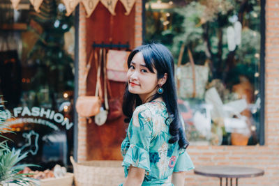 Portrait of smiling young woman standing outdoors