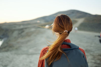 Rear view of woman looking at mountain against sky