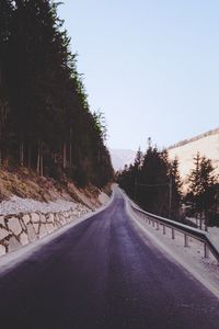 Road amidst trees against sky