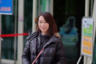 Portrait of smiling woman standing in city