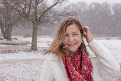 Portrait of smiling woman during snowfall