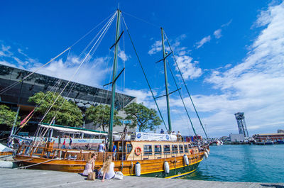 Sailboats moored in sea against sky