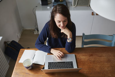 Young woman using laptop at home