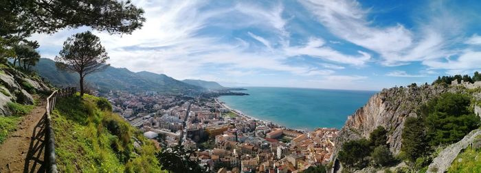 High angle view of townscape by sea against sky