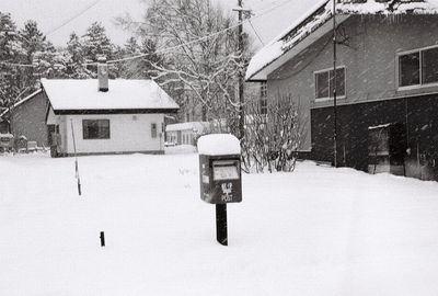 House on snow covered field by building