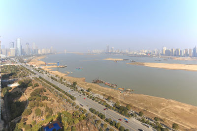 High angle view of road in city by river against sky