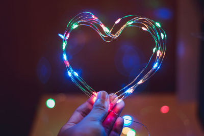 Close-up of hand holding illuminated string light