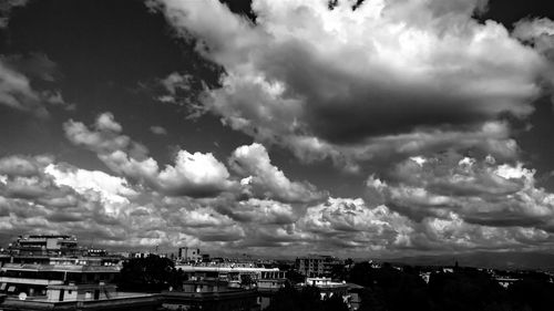 Buildings in city against cloudy sky