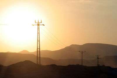 Power lines and array of electric pylons in judea desert