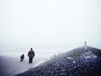 Full length rear view of woman jumping in sea