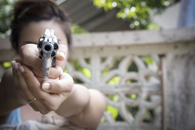 Woman holding handgun outdoors