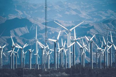 Wind turbines on land against sky